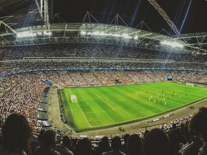 The stadium is alive with cheering football fans, all watching the game unfold