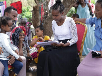 Meron Abeje, a social worker, helps Mulu Admassu—a mother of three who was forced to flee her home due to conflict in Ethiopia’s North Shewa Zone