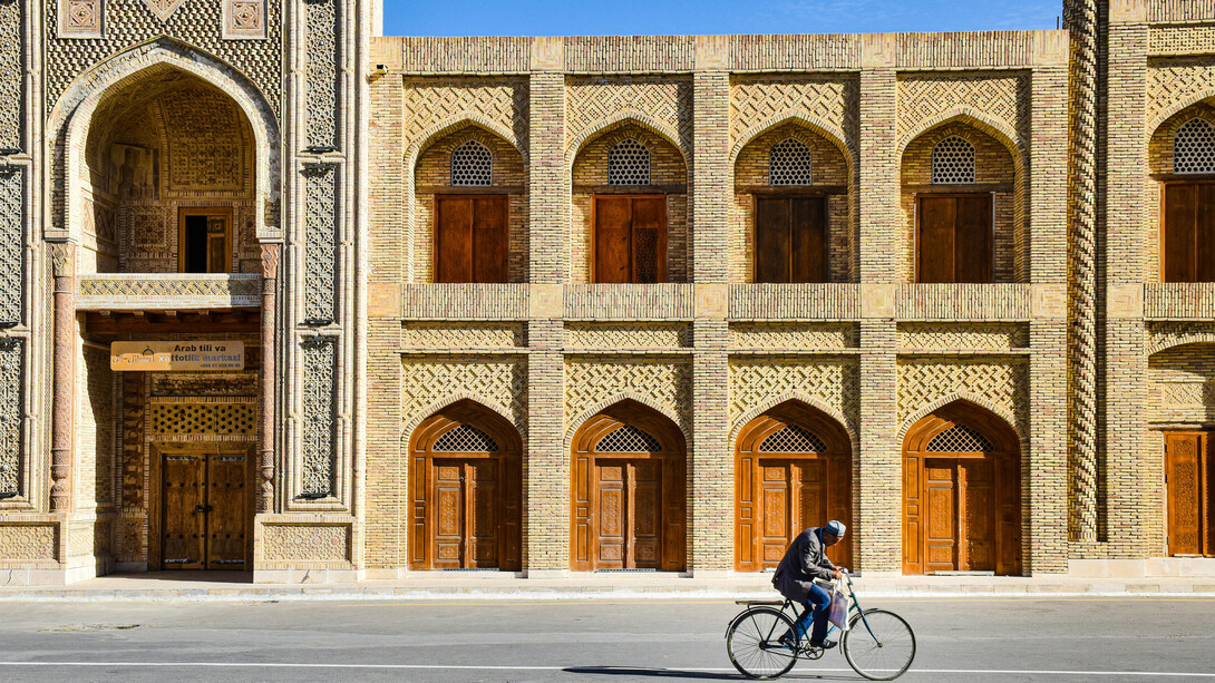 A man riding a bicycle along a street in Bukhara, Uzbekistan