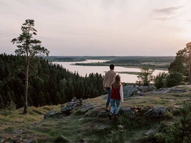As the sun sets in the distance, a couple embraces the warmth of happiness that fills their hearts and minds, reminding them of the essential role serotonin plays in their well-being