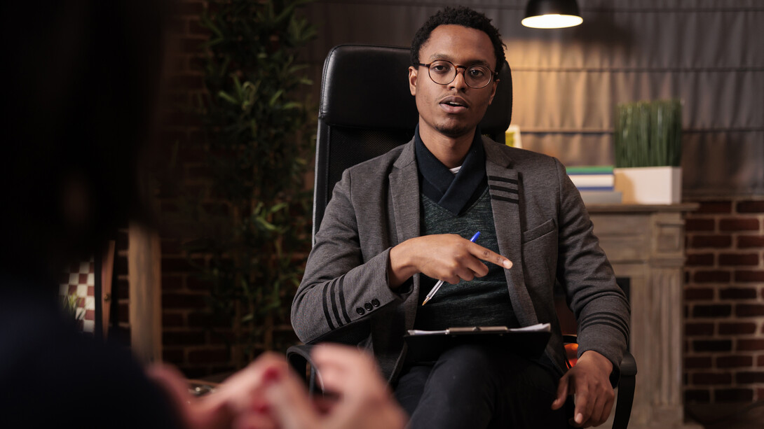 A male psychotherapist conducting a psychoanalysis session with a couple in his office, offering relationship guidance