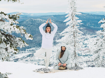 Couples yoga in the mountains, illustrating how breathwork supports lungs in cold weather