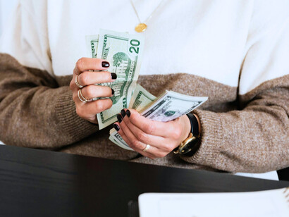 Hands moving through crisp bills, reflecting the tangible weight of economic priorities