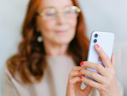 Mulher digita mensagem em seu smartphone. Talvez a escrita tenha começado a morrer no instante em que o corretor automático começou a completar as frases por nós. Ele escreve melhor sim! Sem erros. Sem embargos. Mas também sem alma, sem hesitações, sem aquela falha que nos tornava humanos
