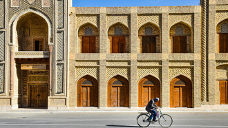 A man riding a bicycle along a street in Bukhara, Uzbekistan