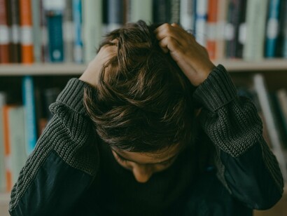 A child grabbing his own hair, displaying how childhood often comes with unexpected disappointments and challenges that become festering wounds later