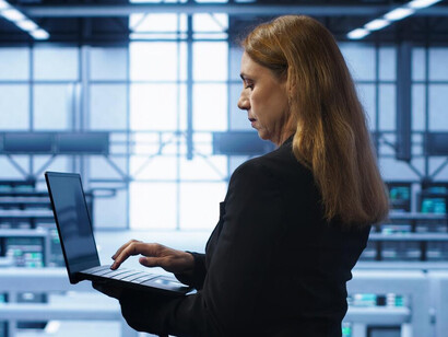 An IT specialist monitoring server infrastructure in a high-tech server hub, ensuring data security and cybersecurity defense in an evolving digital battlefield