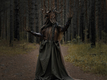 Spooky figure framed by forest darkness, reflecting the shared human response to unseen threats