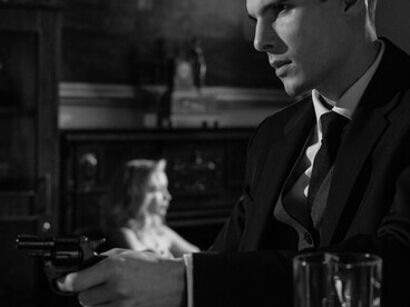A monochrome photograph of men sitting at a bar counter