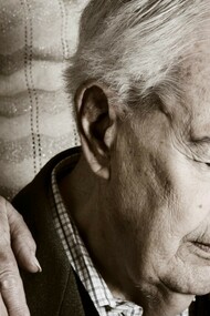 Una mujer anciana apoya su mano sobre el hombro de su marido