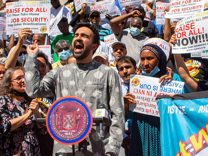 Assemblyman Zohran Mamdani speaking at the Taxi Workers Alliance rally at City Hall, capturing the energy of the New York mayoral election and broader New York City politics