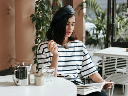 Mulher lê em mesa de café. Você pode ler em qualquer lugar, na sua casa, numa praça, no ônibus, o livro pode ser levado para qualquer canto, cabe em qualquer espaço e pesa pouco. Você não pode levar caixas de som em algumas praias, mas um livro sim, eles podem ser levados a todos os lugares e se adaptam bem a qualquer ambiente. Em seu silêncio eles fazem uma grande revolução



