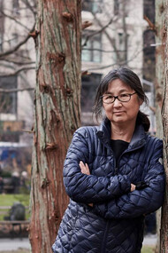 Maya Lin, American designer and sculptor, within her “Ghost Forest” (2021) installation. Courtesy of the artist and Madison Square Park Conservancy. Photo credit: Andy Romer