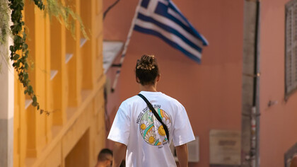 A man walks along a quiet sidewalk in Greece