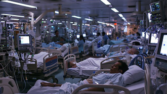 A hospital ward filled with patients receiving medical care in a busy, well-equipped clinical environment