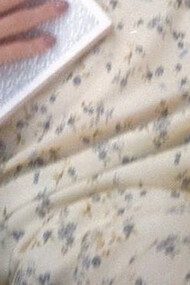 Teenage girl lying on the grass in a yellow sundress with a novel on her chest
