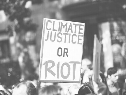 The planet screams while power looks the other way, a powerful message displayed on a placard during a demonstration against climate change