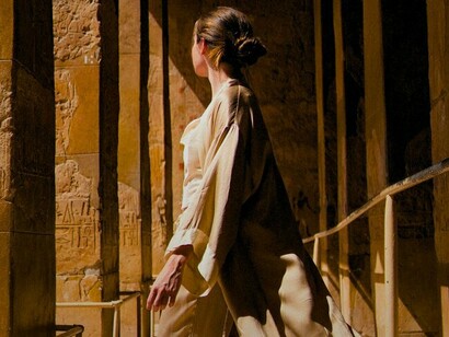 Une femme en manteau beige au temple de Louxor, Louxor, Égypte