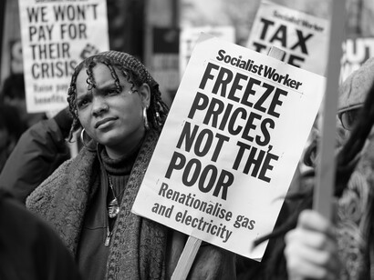 A protester opposite Downing Street listens to one of the speakers on a day of action over the surging cost of living, UK