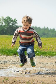 Menino pulando na lama