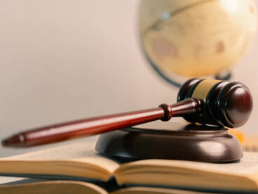 A representation of the legal system featuring law books, a courthouse theme, and a globe to signify international justice