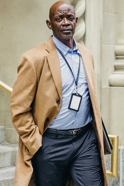 A serious black businessman reviewing documents on building steps, embodying visionary leadership and pioneering spirit