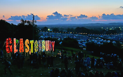 The Glastonbury Festival 2011 captured at night, glowing with lights, music, and the energy of thousands of festivalgoers