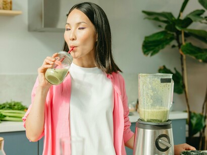 Muher prepara smothie com vegetais. Os Lactobacillus podem também reforçar a eficácia anticancerígena através da modulação imunitária. No cancro da mama, o probiótico Lactobacillus plantarum promove a produção de butirato, que suprime a inflamação, e ajuda a formar um microbiota saudável. Isto inibe o crescimento do tumor



