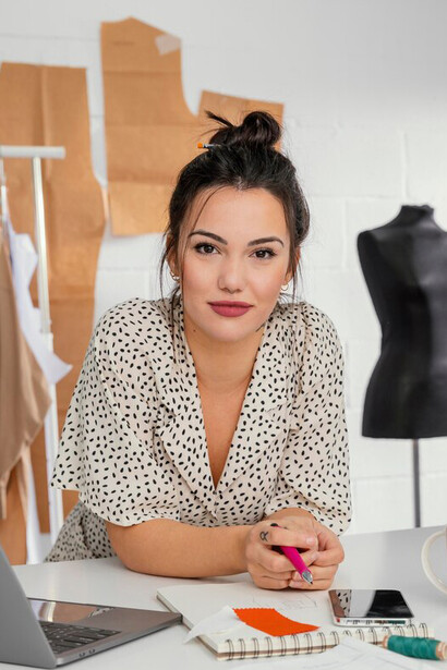 A fashion designer in her workshop, blending traditional craftsmanship with AI-generated designs, shaping the future of digital haute couture