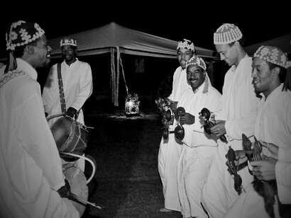 A group of men singing the traditional songs and playing the instruments, showing the relevance of music in tying their culture and history