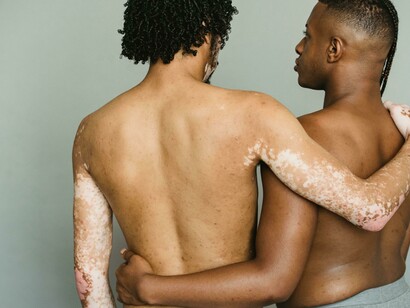 An embrace between multiethnic transgender men, expressing connection and solidarity