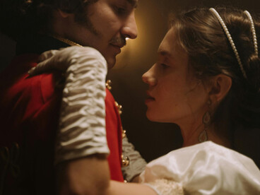 A couple dancing in candlelight, dressed in elegant 18th-century aristocratic fashion