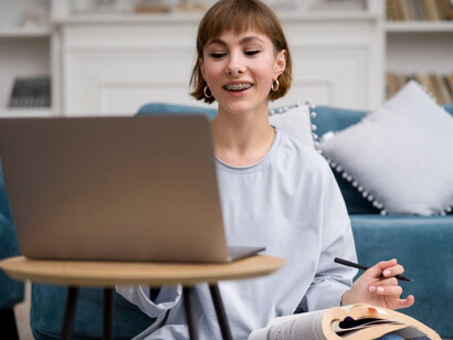 A woman engaged in e-learning at home, participating in a Zoom lecture that blends technology and education