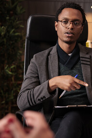 A male psychotherapist conducting a psychoanalysis session with a couple in his office, offering relationship guidance