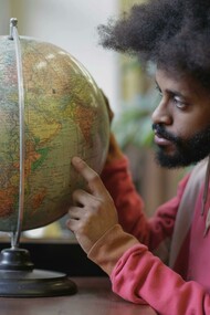 A young Kenyan showcasing countries where English has spread across the globe 