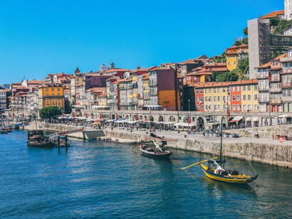 A seaside view of Lisbon under blue skies, reflecting the calm the author finally found after a turbulent journey across Europe