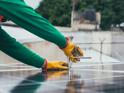 Solar technician installing panels on a rooftop