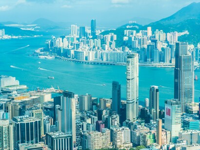 The sweeping aerial view of Victoria Harbour in Hong Kong, capturing the vibrant energy of the city’s skyline and waterfront