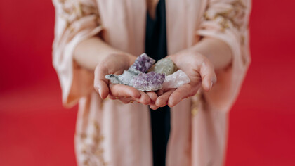 A woman holds healing crystals in her hands, channeling calm and positive energy
