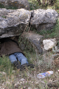 A person stuck all the way to their legs into a bear den