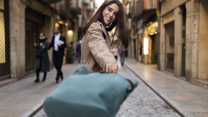 A cheerful female woman walking with her bags in the street