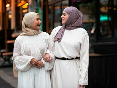 Women wearing hijabs enjoying a walk together on the street