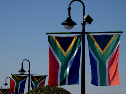 The vibrant colours of the South African flag wave against the backdrop of the blue sky at the Union Buildings in Pretoria, South Africa, celebrating a historic inauguration that marks a significant shift in the nation's governance and political alliances