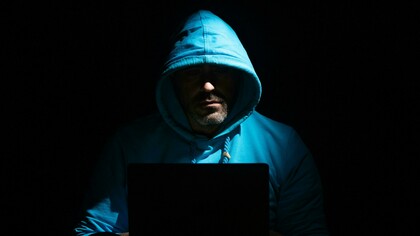 A computer setup with a gaming PC, headphones, and a smartphone on the desk