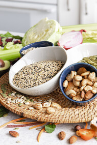 Close-up of a bowl of chia seeds surrounded by other healthy superfoods on a kitchen table