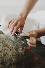 A woman sits at a table, working with a sewing machine to create bio-based textiles, promoting sustainable, circular, and eco-friendly fashion with biodegradable fabrics