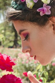 A woman activating her sense of smell by sniffing a flower