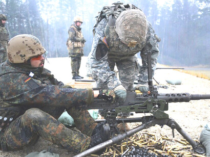 Staff Sgt. Timothy Gibbons of the U.S. Army’s Combined Arms Training Center, 7th Army JMTC, performs a headspace and timing check on a .50-caliber machine gun during weapons familiarization training with German soldiers at Grafenwoehr Training Area, Germany, Dec. 9, 2015