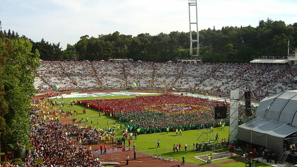Estádio Nacional do Jamor durante o evento "A mais bela bandeira do mundo" - promoção da participação portuguesa no Mundial de Futebol 2006. No que diz respeito à Liga Portuguesa, uma alteração importante seria a mudança de horários dos jogos. Atualmente, muitos jogos ocorrem à noite, dificultando a ida das famílias aos estádios. Realizar os jogos ao fim de semana, durante a tarde, tornaria os estádios mais acessíveis para um público mais amplo, promovendo um ambiente familiar e inclusivo. Além disso, ao realizar os jogos nesse horário, as cidades vizinhas aos estádios poderiam beneficiar do aumento do turismo e da movimentação social, promovendo o futebol como uma atividade divertida para todas as idades