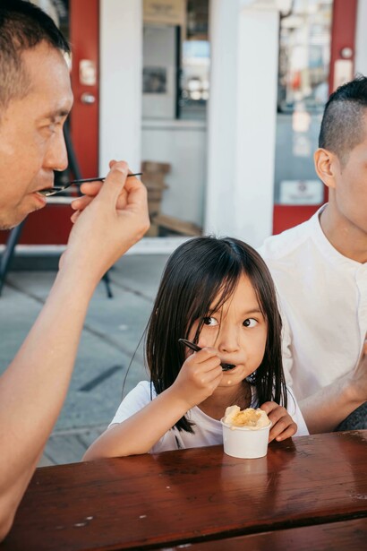 Dad and daughter sharing ice cream on a sunny day